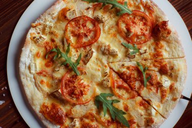 Tahta bir masada etli ve sebzeli pizza. 