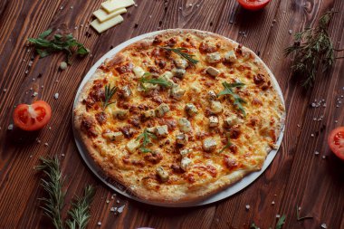 Tahta bir masada etli ve sebzeli pizza. 