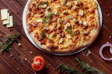 Tahta bir masada etli ve sebzeli pizza. 