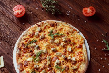 Tahta bir masada etli ve sebzeli pizza. 