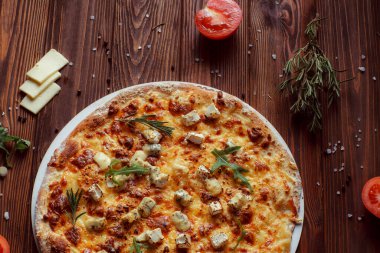 Tahta bir masada etli ve sebzeli pizza. 