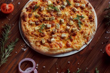 Tahta bir masada etli ve sebzeli pizza. 