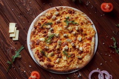 Tahta bir masada etli ve sebzeli pizza. 