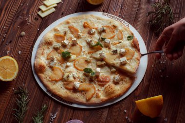 Tahta bir masada etli ve sebzeli pizza. 