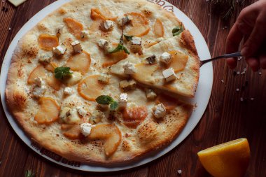 Tahta bir masada etli ve sebzeli pizza. 