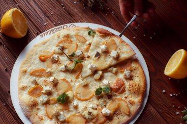 Tahta bir masada etli ve sebzeli pizza. 