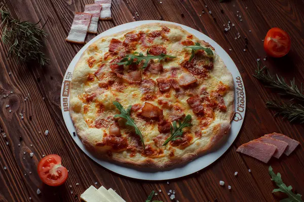 Tahta bir masada etli ve sebzeli pizza. 