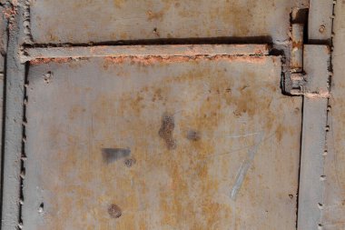 Kilitli paslı metal bir kapı.