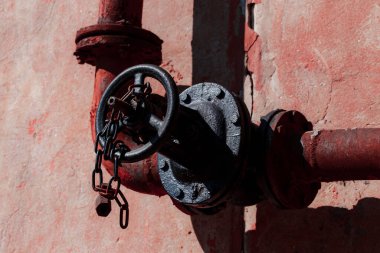 Kırmızı saplı eski paslı metal boru.