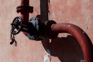 Kırmızı ve sarı suyu olan paslı metal bir boru.