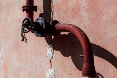 Kırmızı saplı eski paslı metal boru.
