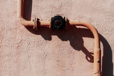 Duvardaki paslı metal boru.