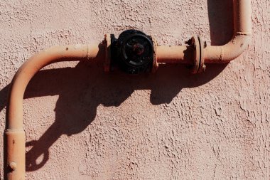 Duvardaki paslı metal boru.