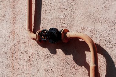 Duvardaki paslı metal boru.
