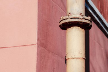 Duvardaki paslı metal boru.