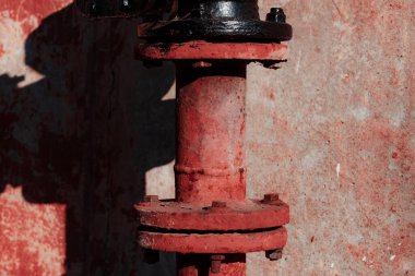 Binanın arka planında paslı metal bir boru var.