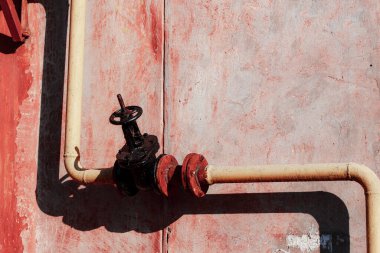 Duvardaki paslı metal boru.