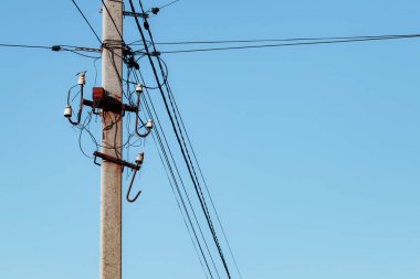 Mavi gökyüzünün arka planında elektrik kabloları