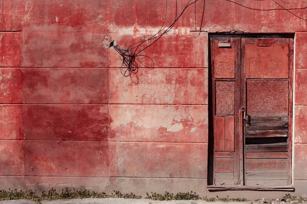 Kırmızı ve yeşil boyalı paslı metal kapı.