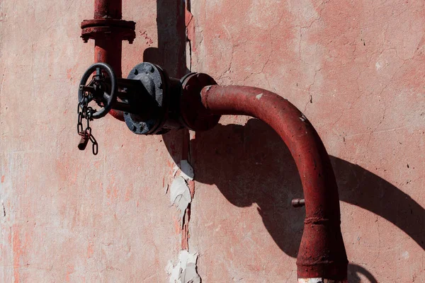Kırmızı saplı eski paslı metal boru.