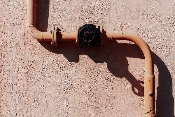 Duvardaki paslı metal boru.