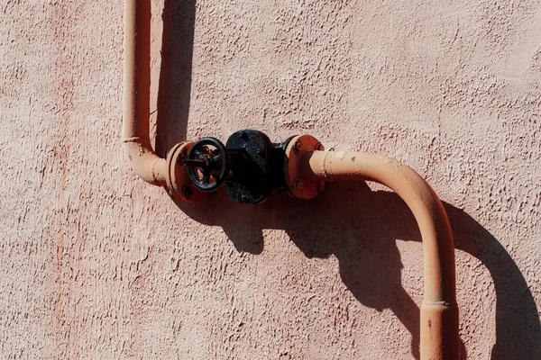 Duvardaki paslı metal boru.
