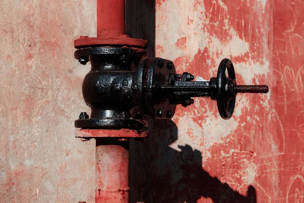 Kırmızı saplı eski paslı metal boru.