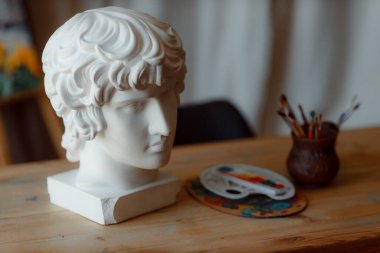 Tahta bir masada alçı heykel. Çizim dersleri. Sanat okulu konsepti.