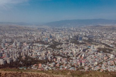 TBILISI, GEORGIA - 9 AĞUSTOS 2021: Dağlık arazili kırmızı tuğlalı evlerin olduğu eski şehir manzarası.