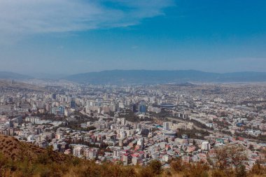 TBILISI, GEORGIA - 9 AĞUSTOS 2021: Dağlık arazili kırmızı tuğlalı evlerin olduğu eski şehir manzarası.