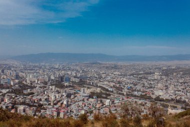 TBILISI, GEORGIA - 9 AĞUSTOS 2021: Dağlık arazili kırmızı tuğlalı evlerin olduğu eski şehir manzarası.