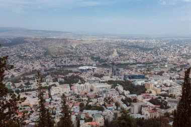 TBILISI, GEORGIA - 9 AĞUSTOS 2021: Dağlık arazili kırmızı tuğlalı evlerin olduğu eski şehir manzarası.