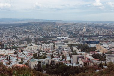 TBILISI, GEORGIA - 9 AĞUSTOS 2021: Dağlık arazili kırmızı tuğlalı evlerin olduğu eski şehir manzarası.