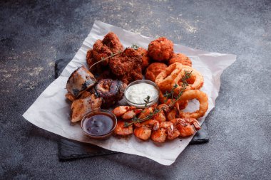 Siyah arka planı olan tabakta taze deniz ürünleri.