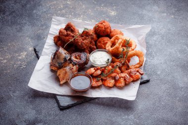 Siyah arka planı olan tabakta taze deniz ürünleri.