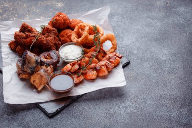 Siyah arka planı olan tabakta taze deniz ürünleri.