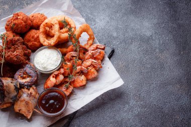 Siyah arka planı olan tabakta taze deniz ürünleri.