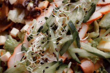 Pastırmalı yaz salatası, salatalık, peynir kübü ve mantar. Siyah tabakta yeşil salata, siyah arka planda. Bir yazı için boş yer. Yukarıdan görüntüle.