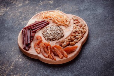 Ahşap çatal üzerinde bira için atıştırmalıklar. Dilimlenmiş balık dilimleri ve sopa şeklinde. Fındık ve peynir karışımı. Koyu dokuda yemek. Çevre dostu sofra takımı.