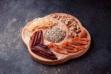 Ahşap çatal üzerinde bira için atıştırmalıklar. Dilimlenmiş balık dilimleri ve sopa şeklinde. Fındık ve peynir karışımı. Koyu dokuda yemek. Çevre dostu sofra takımı.