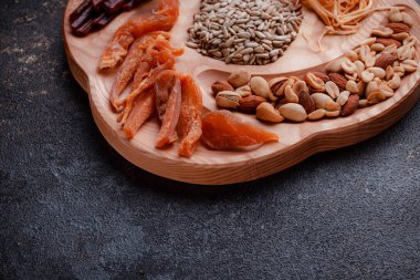 Ahşap çatal üzerinde bira için atıştırmalıklar. Dilimlenmiş balık dilimleri ve sopa şeklinde. Fındık ve peynir karışımı. Koyu dokuda yemek. Çevre dostu sofra takımı.