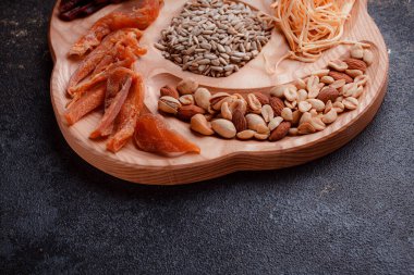 Ahşap çatal üzerinde bira için atıştırmalıklar. Dilimlenmiş balık dilimleri ve sopa şeklinde. Fındık ve peynir karışımı. Koyu dokuda yemek. Çevre dostu sofra takımı.