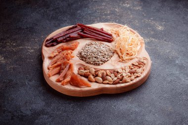 Ahşap çatal üzerinde bira için atıştırmalıklar. Dilimlenmiş balık dilimleri ve sopa şeklinde. Fındık ve peynir karışımı. Koyu dokuda yemek. Çevre dostu sofra takımı.