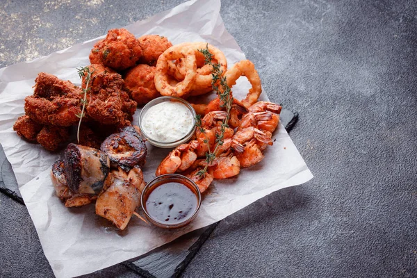 Siyah arka planı olan tabakta taze deniz ürünleri.