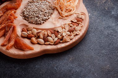 Ahşap çatal üzerinde bira için atıştırmalıklar. Dilimlenmiş balık dilimleri ve sopa şeklinde. Fındık ve peynir karışımı. Koyu dokuda yemek. Çevre dostu sofra takımı.