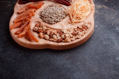 Ahşap çatal üzerinde bira için atıştırmalıklar. Dilimlenmiş balık dilimleri ve sopa şeklinde. Fındık ve peynir karışımı. Koyu dokuda yemek. Çevre dostu sofra takımı.