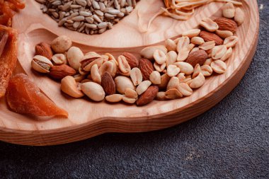 Ahşap çatal üzerinde bira için atıştırmalıklar. Dilimlenmiş balık dilimleri ve sopa şeklinde. Fındık ve peynir karışımı. Koyu dokuda yemek. Çevre dostu sofra takımı.