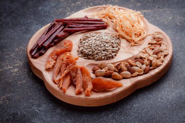 Ahşap çatal üzerinde bira için atıştırmalıklar. Dilimlenmiş balık dilimleri ve sopa şeklinde. Fındık ve peynir karışımı. Koyu dokuda yemek. Çevre dostu sofra takımı.