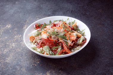 Domatesli panzanella salatası ve taze yeşillikli kağıt. Karanlık masada taze sebze karışımı. Üst Görünüm, Boşluğu Kopyala.