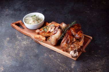 Kemiğin üzerinde büyük bir parça kızarmış et. Josper 'da kızartılmış sarımsak. Büyük parçalar halinde ızgara patates..